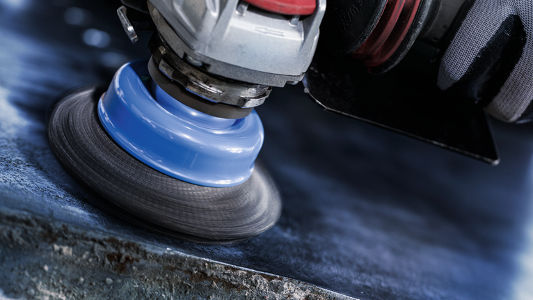 Bàn chải tròn X-Lock PRO Metal clean, 75 x 0,3 mm Một người mặc đồ bảo hộ đang đánh bóng kim loại bằng dụng cụ quay.