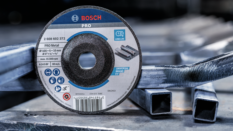 Đĩa cắt được đặt trên các ống kim loại xếp chồng trong môi trường công nghiệp.