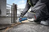 Một người mặc đồ bảo hộ đang mài cốt thép tại công trường xây dựng, tạo ra tia lửa.