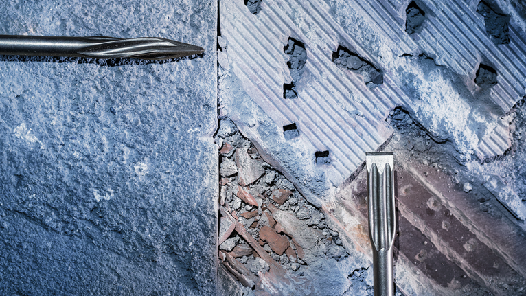 Hai mũi khoan đục để loại bỏ bê tông khỏi bề mặt tường.