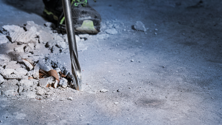 Mũi khoan phá vỡ bê tông tại công trường xây dựng.