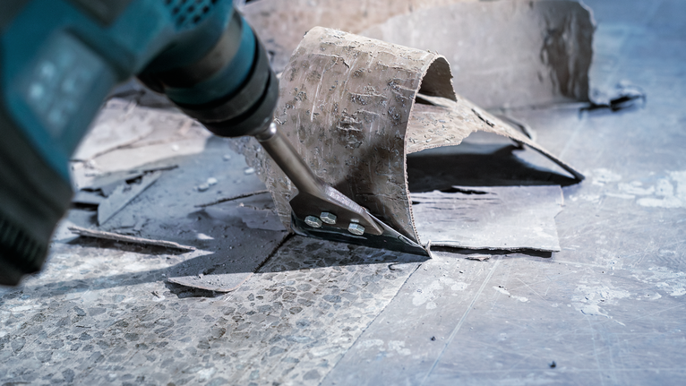 Dụng cụ điện có đầu đục để loại bỏ sàn cũ khỏi bề mặt cứng.