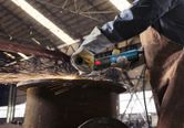 Một người mặc đồ bảo hộ đang mài kim loại, tạo ra tia lửa trong môi trường công nghiệp.