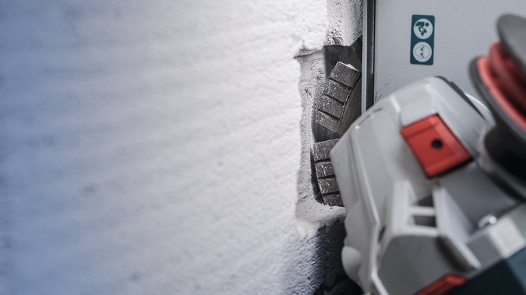 Máy cắt tường cắt rãnh thẳng vào tường bê tông.