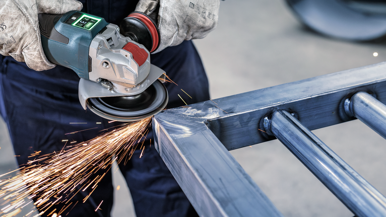 Người đeo thiết bị an toàn mài kim loại, tạo ra tia lửa sáng.