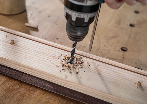 Bộ mũi khoan đầu đinh nhỏ PRO Wood, 7 chiếc Người đang sử dụng máy khoan để tạo lỗ trên tấm gỗ.