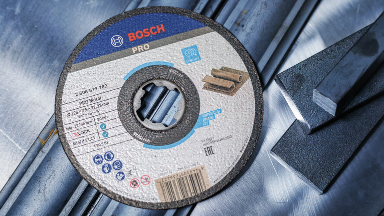 Đá cắt liên kết PRO Metal, 125 x 1,6 x 22,23 mm, X-Lock Đĩa cắt kim loại nằm trên thanh thép.