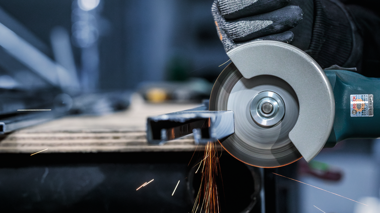 Đá cắt PRO Stainless Steel and Metal, 105 x 1 x 16 mm Người đeo thiết bị an toàn sử dụng máy mài góc để cắt kim loại, tạo ra tia lửa.