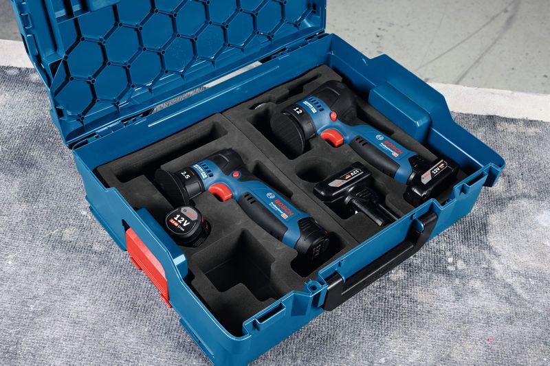 GEX 12V-77 Dụng cụ điện không dây và pin được sắp xếp trong hộp đựng màu xanh trên bề mặt làm việc.