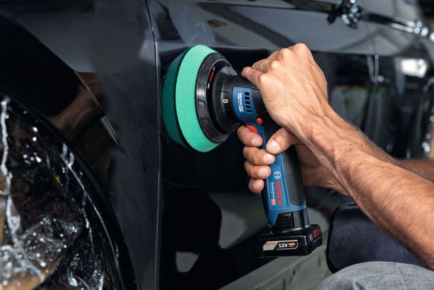 GPX 12V-125 Một người sử dụng máy đánh bóng không dây trên cửa ô tô.