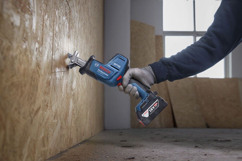GSA 18V-24 Một người mặc đồ bảo hộ đang sử dụng máy cưa lọng để cắt ván ép.