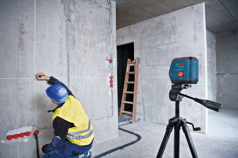 GCL 15-12 XG Một người mặc thiết bị an toàn đang đánh dấu bức tường bằng máy cân bằng laser.