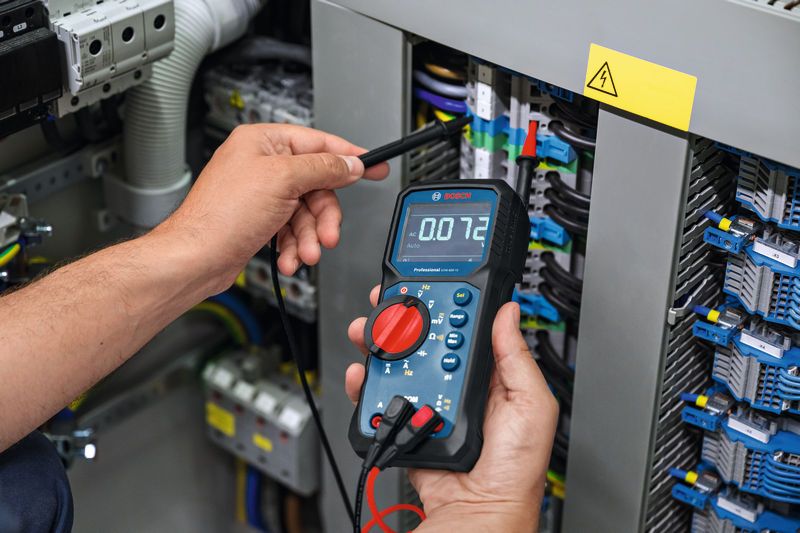 Người ta đo điện áp trên bảng điện bằng đồng hồ vạn năng kỹ thuật số.