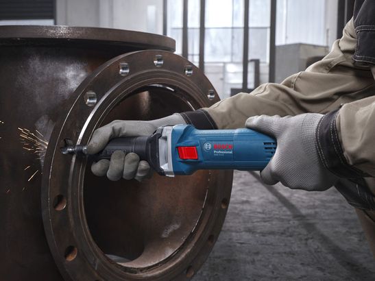 GGS 5 LS Một người đeo thiết bị an toàn sử dụng máy mài góc để mài cạnh của một ống kim loại.