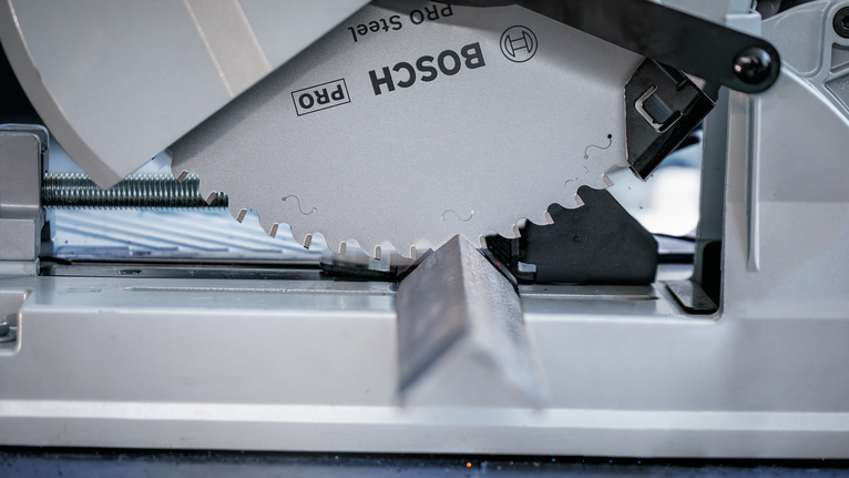 Lưỡi cưa tròn cắt xuyên qua thanh kim loại theo một góc.