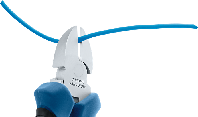 Một người đang dùng kìm để cắt một sợi dây điện màu xanh.