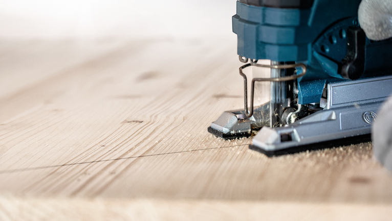Lưỡi cưa lọng EXPERT ‘Wood 2-side clean’ T 308 B, 5 chiếc Một người điều khiển máy cưa lọng theo đường đã đánh dấu để cắt một tấm ván gỗ.
