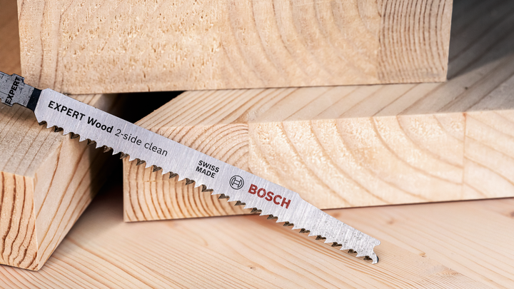 Object #200597870: 2793296_app_web_02 Lưỡi cưa đặt trên các mảnh gỗ cắt xếp chồng lên nhau.