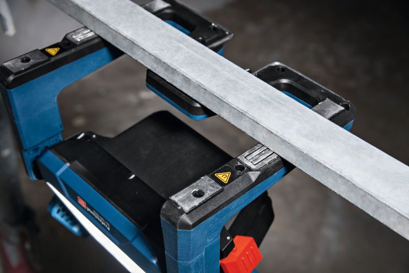 Đèn công trường không dây chiếu sáng không gian làm việc bên dưới một thanh kim loại.