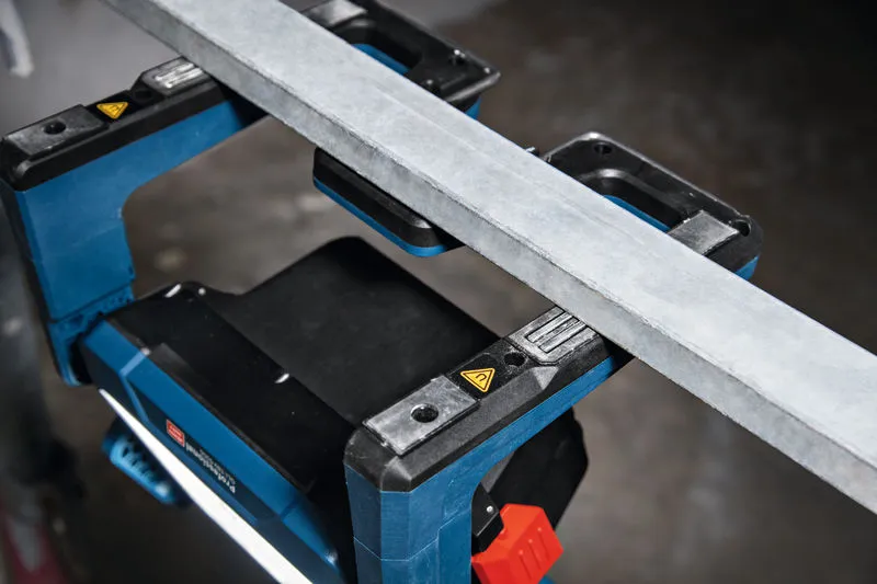 Đèn công trường không dây chiếu sáng không gian làm việc bên dưới một thanh kim loại.