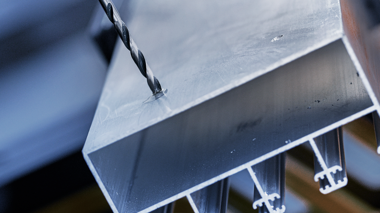 Mũi khoan tạo lỗ trên thanh kim loại dày.