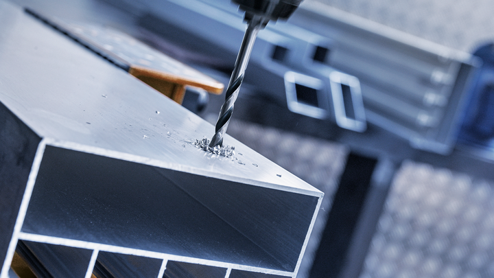 Khoan lỗ trên thanh kim loại.