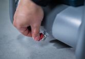 Một người vặn van màu đỏ trên một chiếc máy hình trụ màu xám.